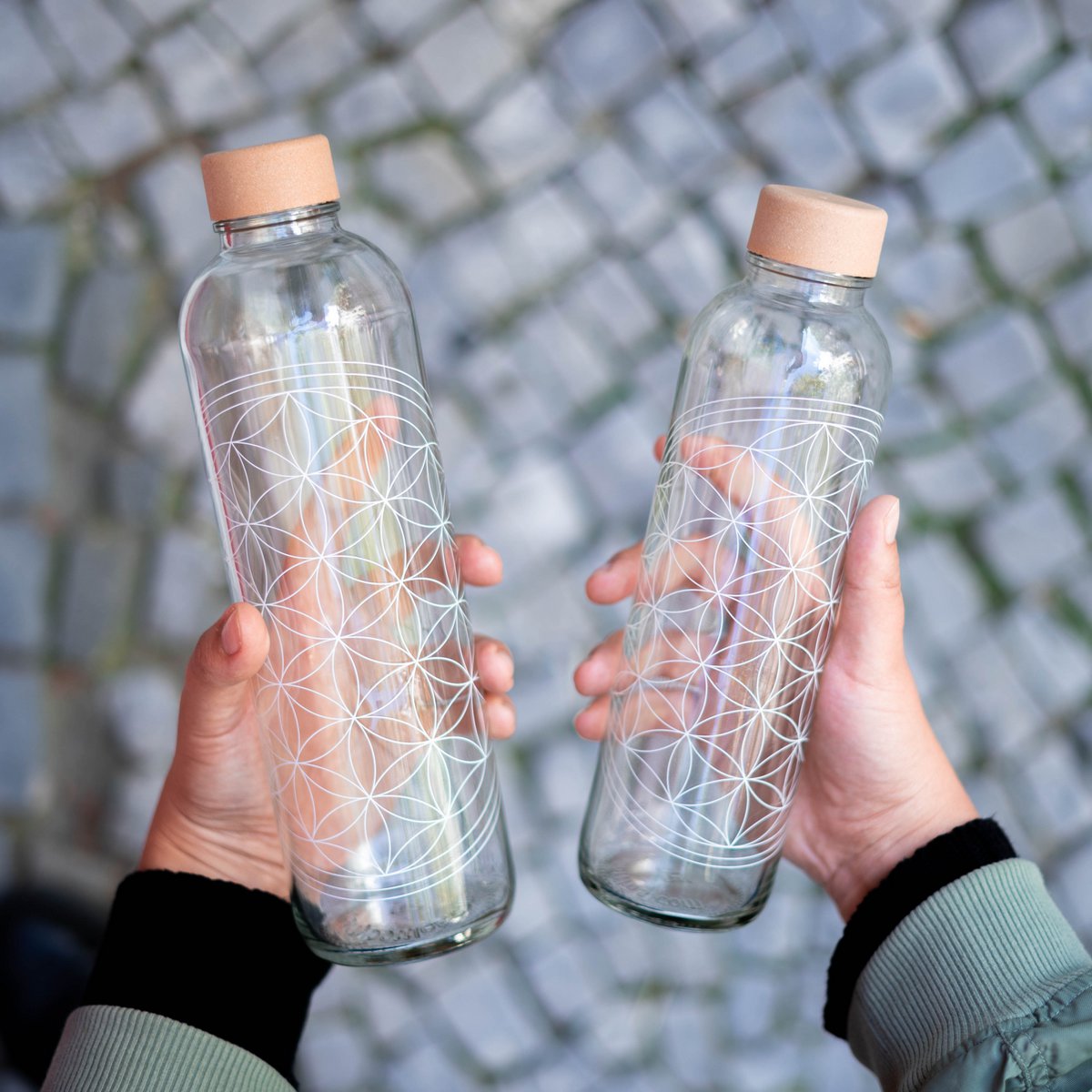 Twee drinkflessen Flower of Life in de hand