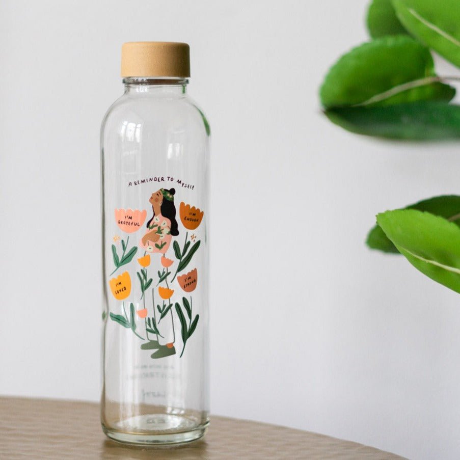 Drinkfles Reminder to Myself op tafel naast een plant