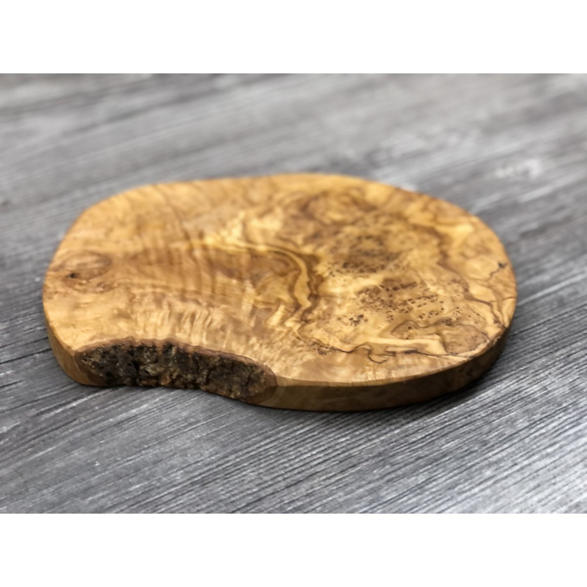 Kleine snijplank van olijfhout van bovenaf, op een houten tafel