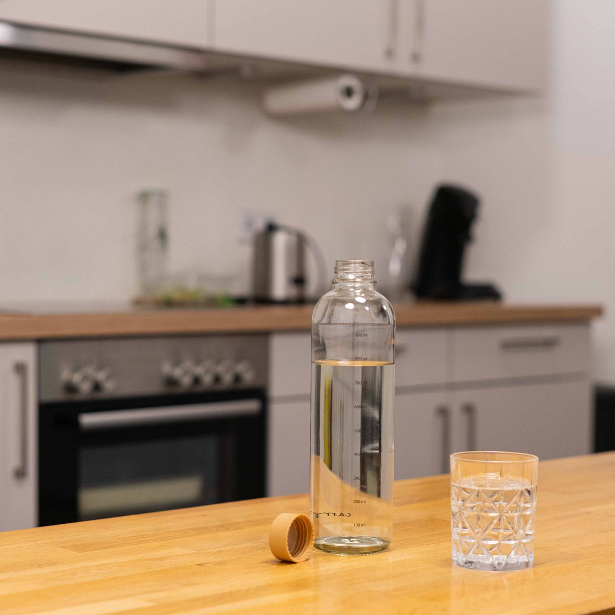 Drinkfles Hydration Booster in de keuken naast een glas