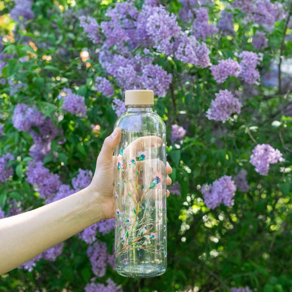 Drinkfles Hanami in de hand voor paarse bloemen