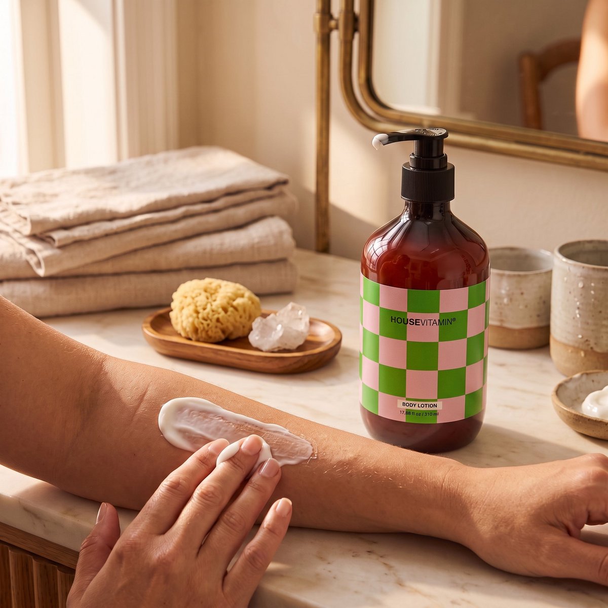 Bodylotion Komkommer op een badkamerplank, iemand smeert lotion op de arm