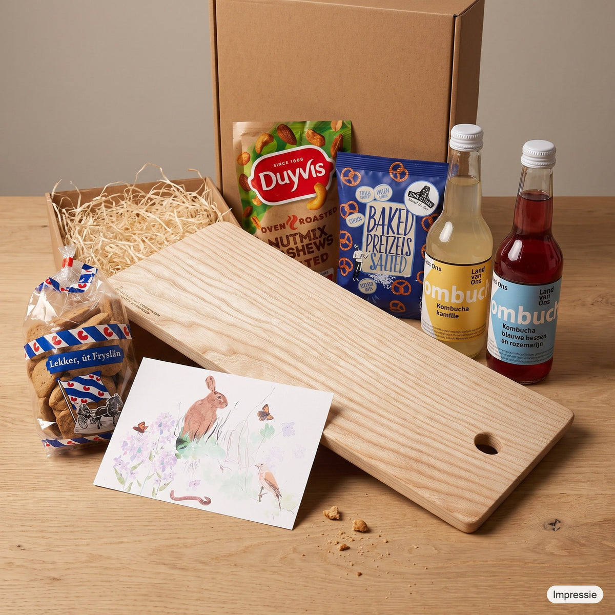 Impressie van het borrelpakket: lange borrelplank van stadshout met dúmkes, notenmix, pretzels, twee kombucha en een kaart