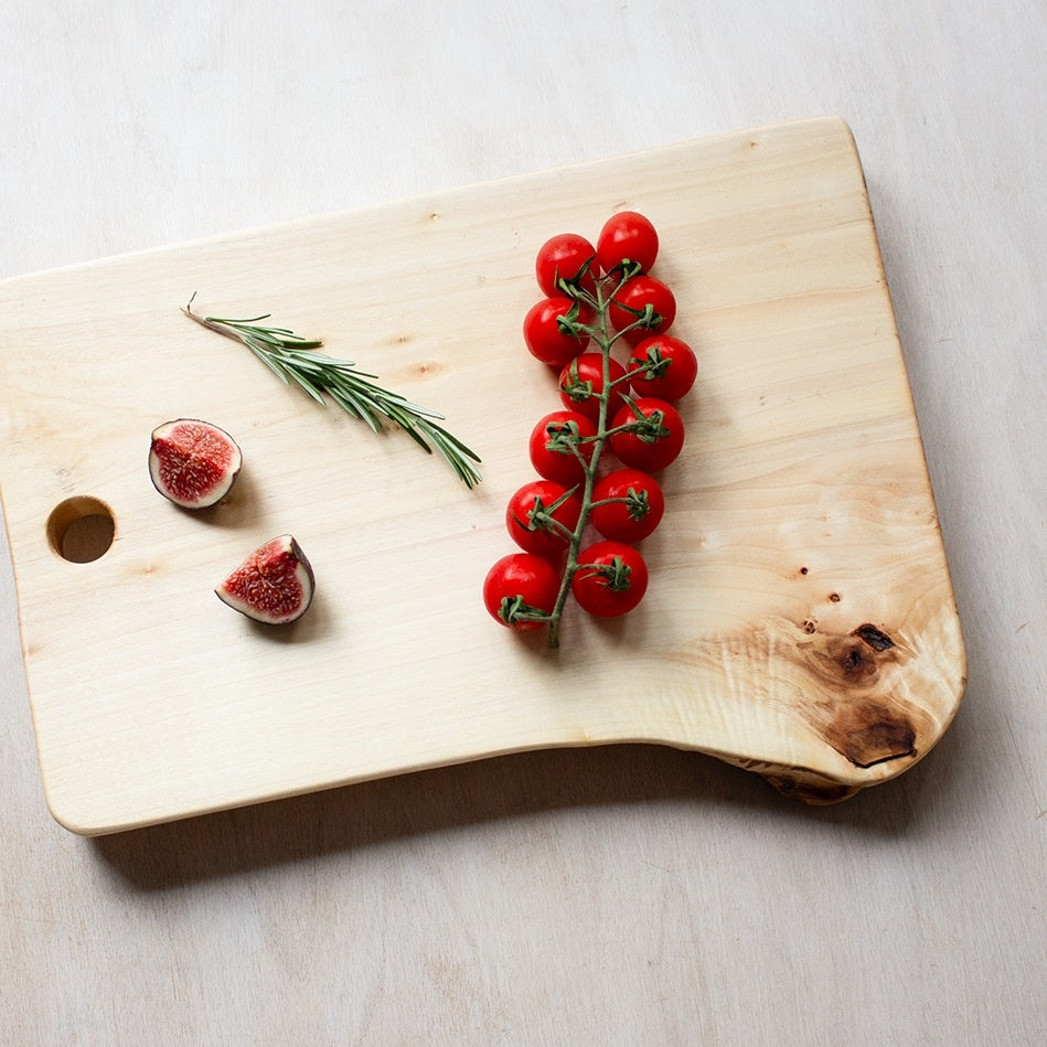 Robuuste borrelplank van stadshout met cherrytomaatjes, vijgen en rozemarijn