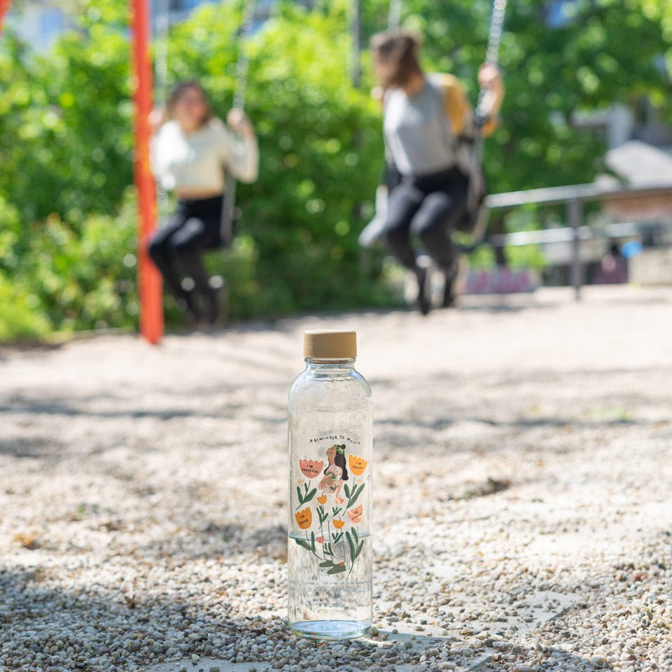 Drinkfles Reminder to Myself op het grind bij een speeltuin