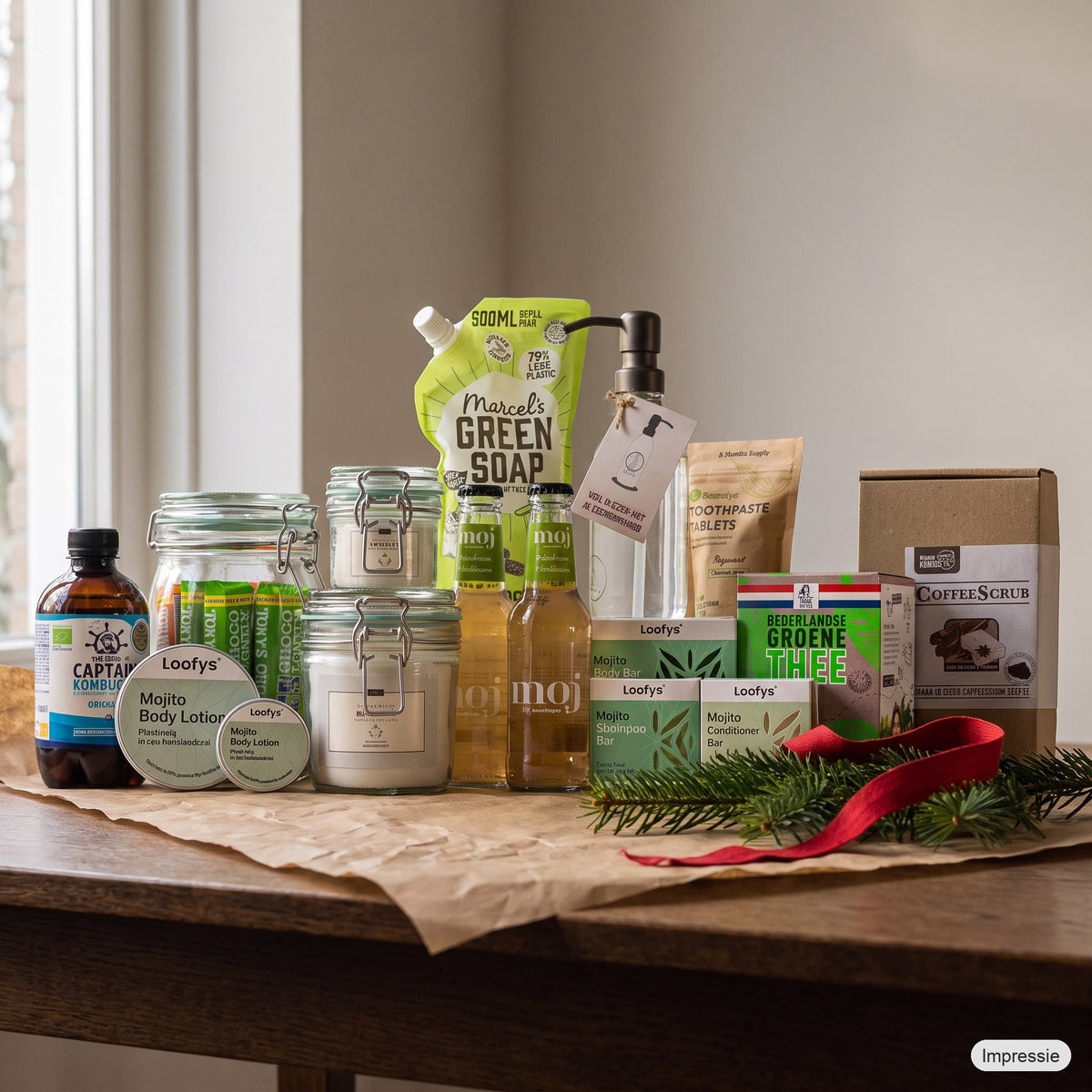Feel Good Kerstpakket - XL - Groen op een houten tafel met kraftpapier, dennentakken en een rood lint (impressie)