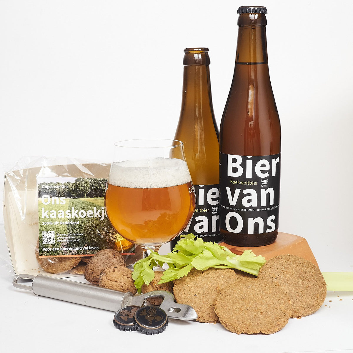 Boekweitbier van Land van Ons in een glas, met flesjes en koekjes ernaast