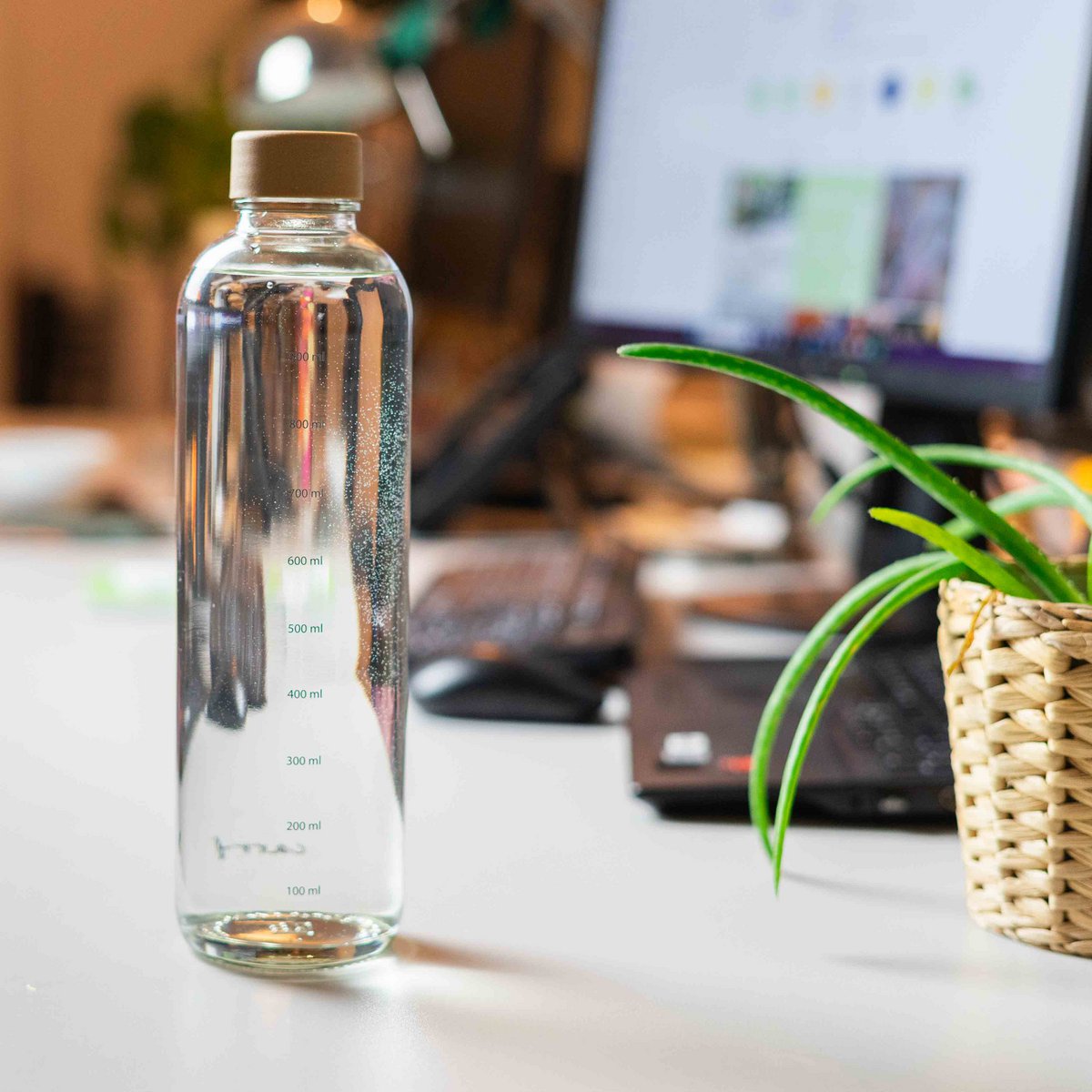 Drinkfles Hydration Booster op een bureau naast een laptop