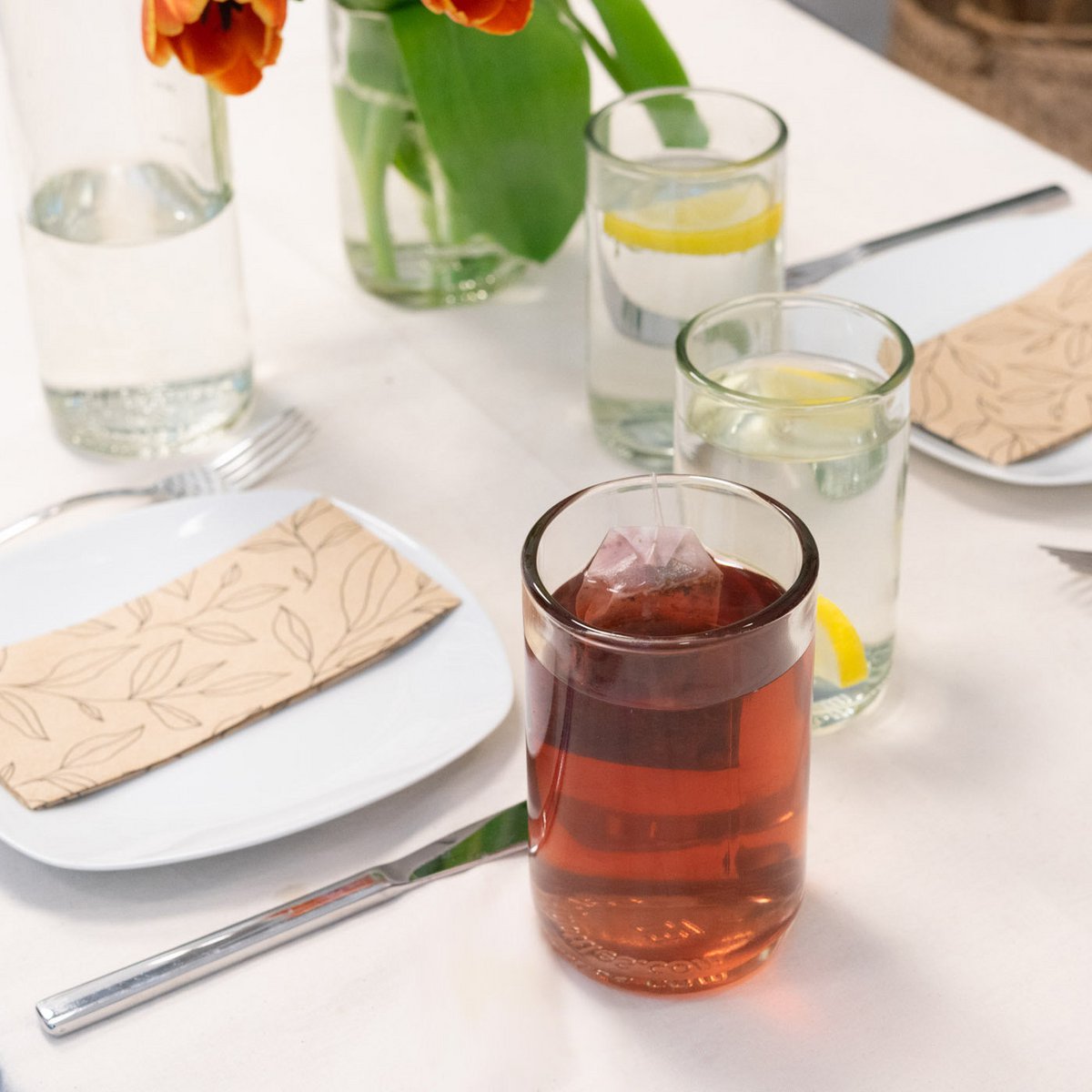 Drinkglazen met drinken op een gedekte tafel