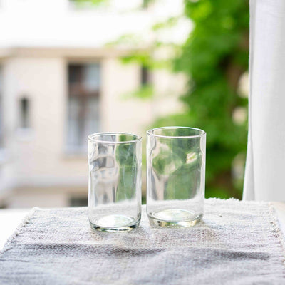 Twee drinkglazen op tafel bij het raam