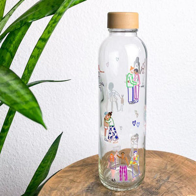Drinkfles Love is Love op een houten krukje naast een plant