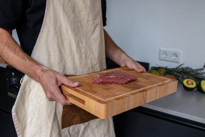 Snijplank van beukenhout met handgrepen, vastgehouden