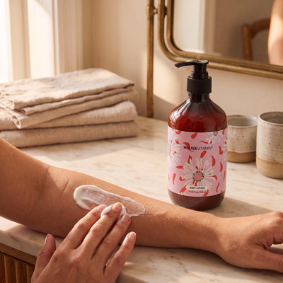 Bodylotion Pioenroos op een badkamerplank, iemand smeert lotion op de arm