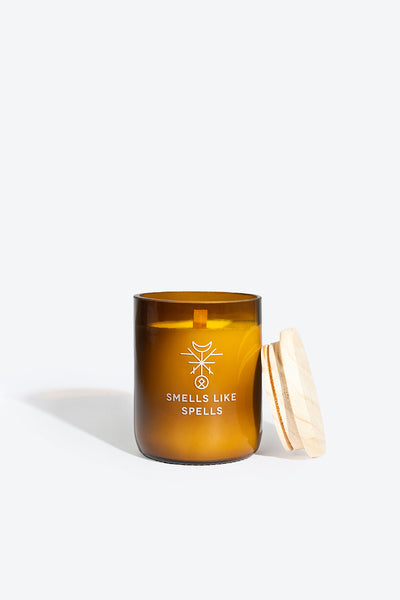 Geopende geurkaars van Smells Like Spells met het houten deksel ertegenaan