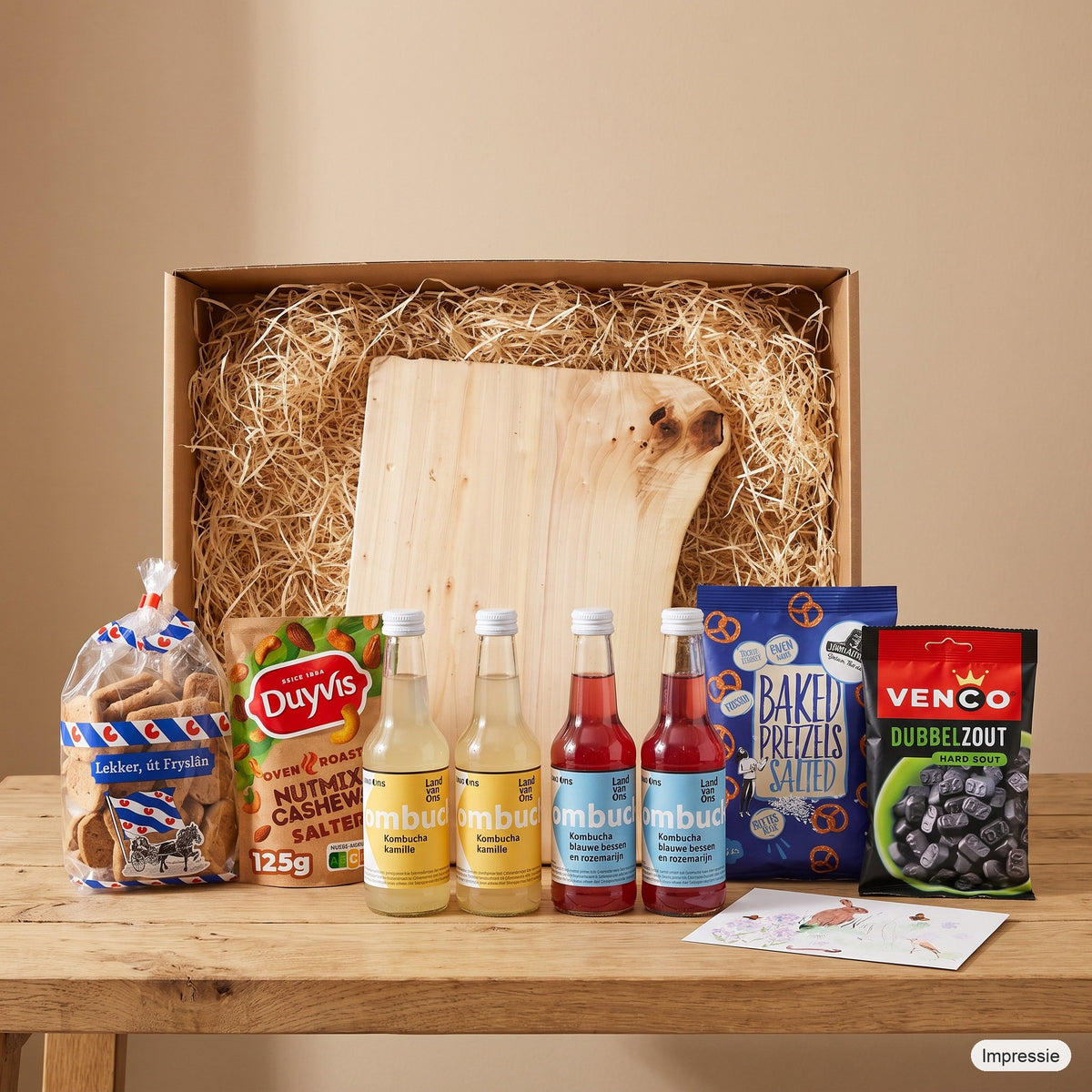 Impressie van het grote borrelpakket met de doos, de robuuste borrelplank en de lekkernijen op tafel