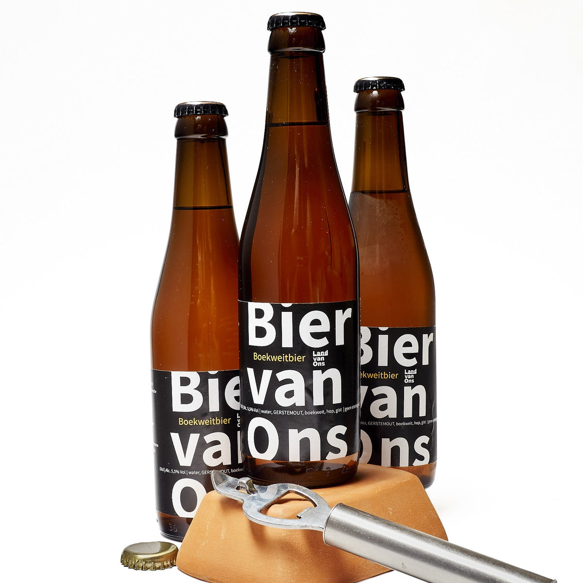 Drie flesjes Bier van Ons, blond boekweitbier van Land van Ons, met een flesopener